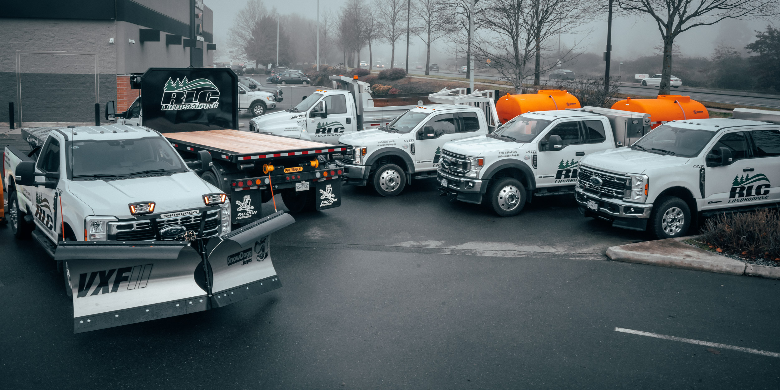 A lineup of heavy duty landscaping trucks and equipment